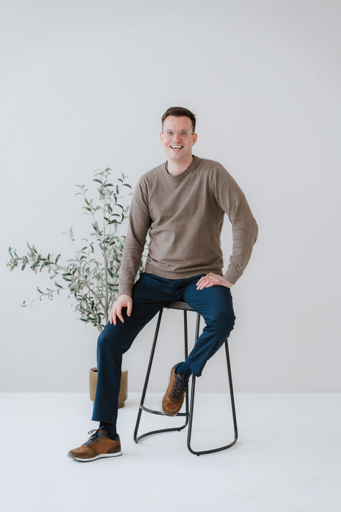 Hochzeitsfotograf Pfalz auf Hocker in die Kamera lachend